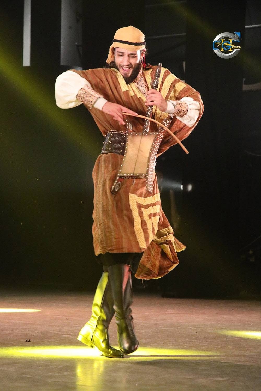 Mahmoud captured mid-performance under stage light
